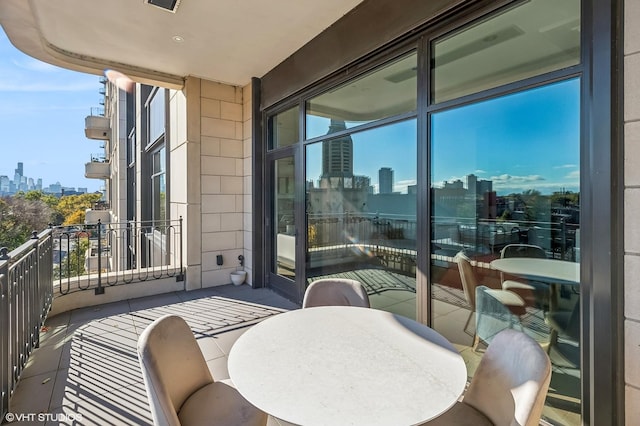 balcony with outdoor dining area and a view of city