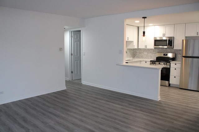 kitchen with tasteful backsplash, decorative light fixtures, dark hardwood / wood-style floors, stainless steel appliances, and white cabinets