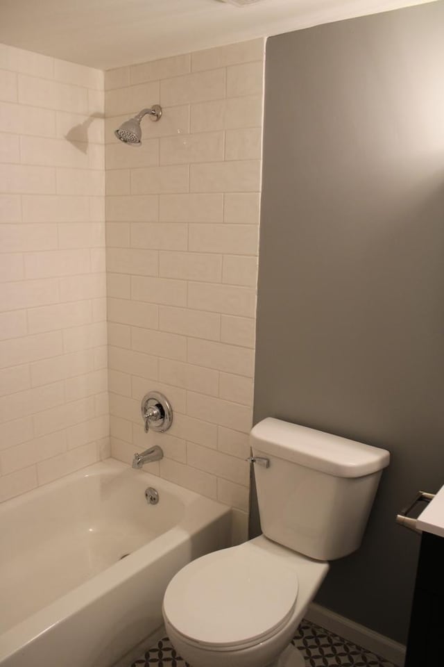 full bathroom featuring vanity, tiled shower / bath combo, tile patterned floors, and toilet