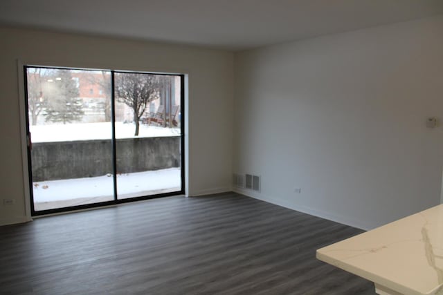 unfurnished room with dark wood-type flooring