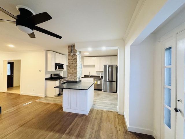 kitchen with appliances with stainless steel finishes, light hardwood / wood-style flooring, and white cabinets