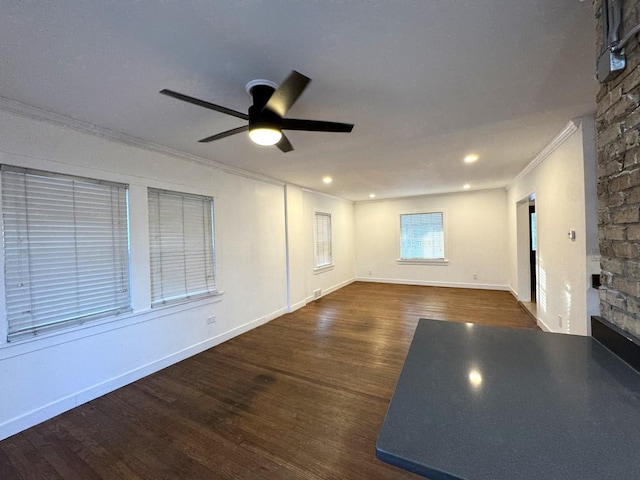 unfurnished living room featuring crown molding, ceiling fan, and dark hardwood / wood-style floors