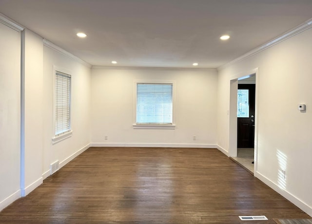 spare room featuring ornamental molding, dark hardwood / wood-style floors, and plenty of natural light