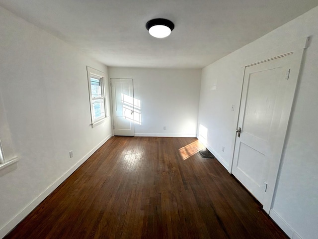 spare room with dark wood-type flooring