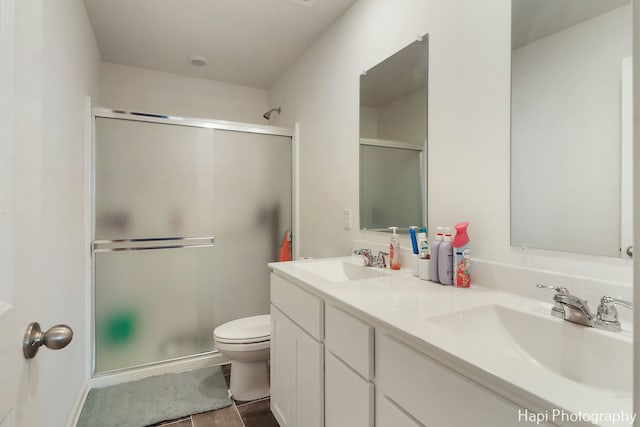 bathroom with tile patterned floors, vanity, toilet, and an enclosed shower