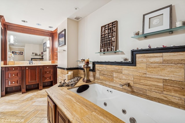 bathroom with vanity, parquet floors, and a bath