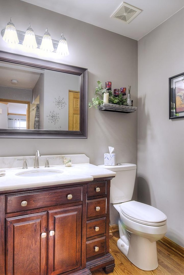 bathroom with vanity, hardwood / wood-style floors, and toilet