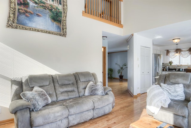 living room featuring a towering ceiling and light wood-type flooring