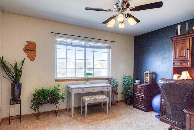 carpeted home office featuring ceiling fan