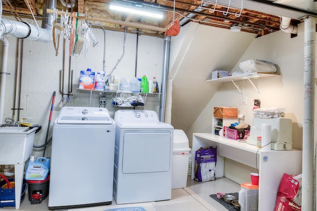 clothes washing area with washer and clothes dryer and sink