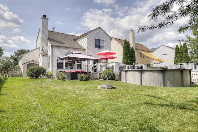 rear view of house with a gazebo, a lawn, and an outdoor fire pit