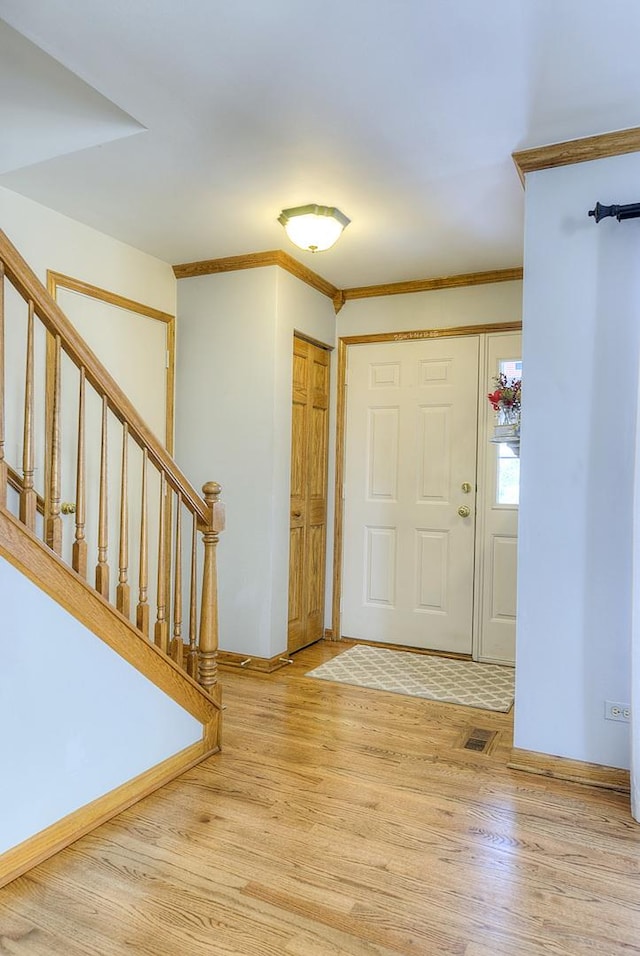 entryway featuring crown molding and hardwood / wood-style flooring