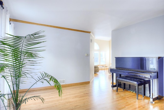 misc room featuring crown molding and light hardwood / wood-style flooring