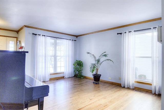 sitting room with ornamental molding and light hardwood / wood-style flooring