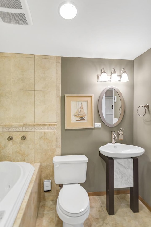 bathroom with tile patterned flooring, toilet, visible vents, baseboards, and a tub with jets