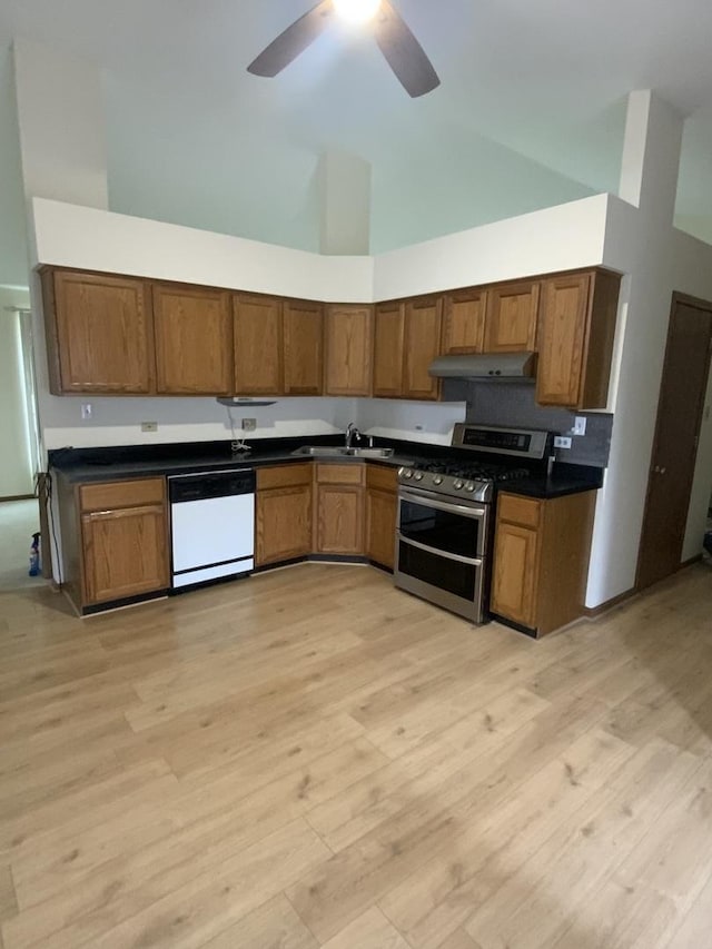 kitchen with double oven range, high vaulted ceiling, sink, and dishwasher