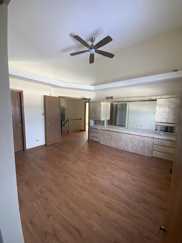 unfurnished living room with high vaulted ceiling, dark wood-type flooring, and ceiling fan