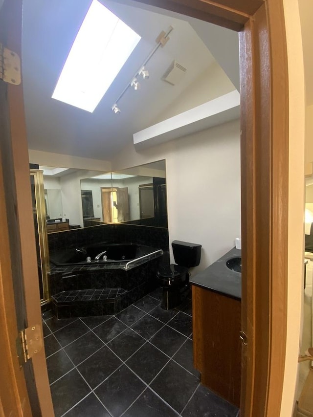 bathroom featuring tile patterned flooring, vanity, and a skylight