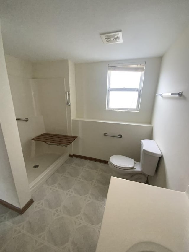 bathroom with toilet and a shower