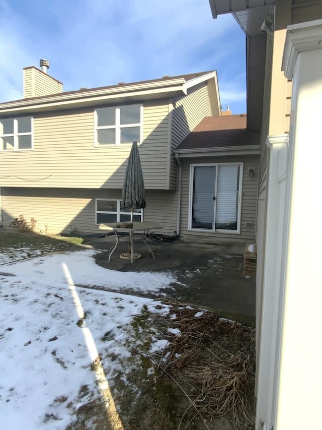 view of snow covered back of property