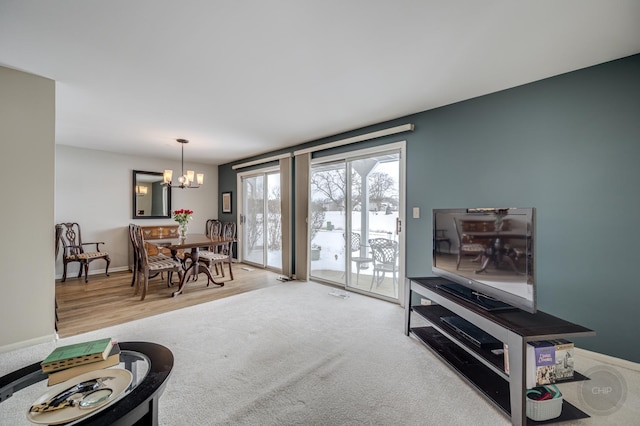 living room featuring an inviting chandelier and carpet floors