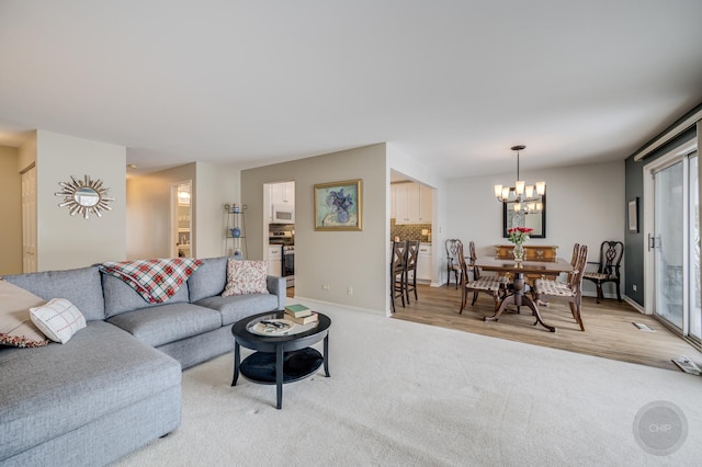 living room featuring light carpet and a notable chandelier