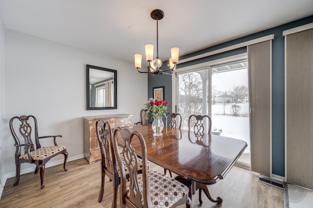 dining space with a notable chandelier and light wood-type flooring