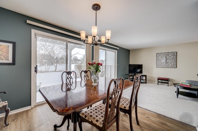 dining space featuring wood-type flooring and a chandelier