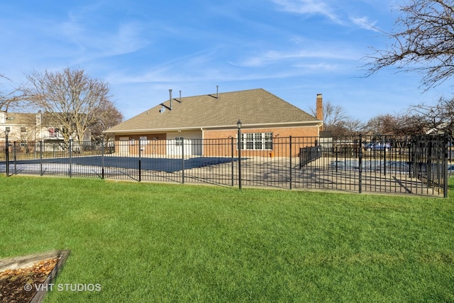 back of property featuring a covered pool, a lawn, and a patio area