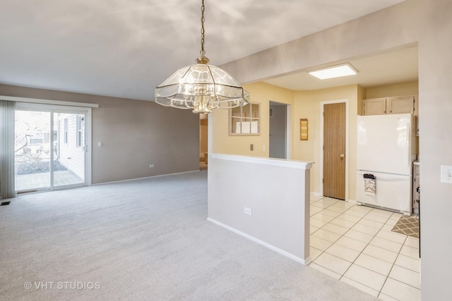 kitchen featuring light carpet, hanging light fixtures, white refrigerator, light brown cabinets, and a notable chandelier