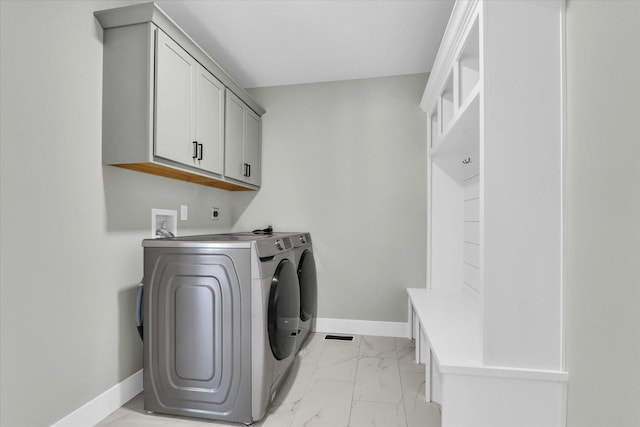 laundry area with cabinets and washing machine and clothes dryer