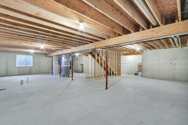 basement featuring brick wall and heating unit