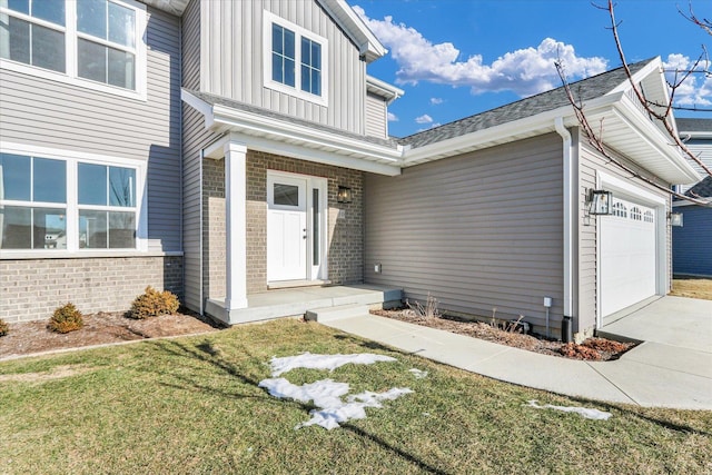 view of exterior entry with a garage and a yard