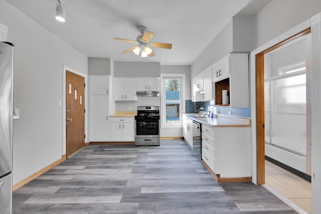 kitchen with white cabinetry, dishwasher, sink, backsplash, and gas stove