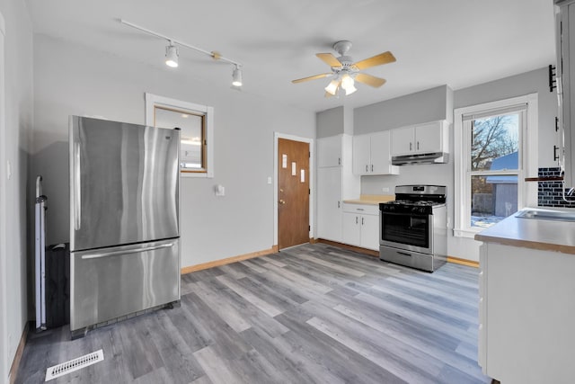 kitchen with sink, ceiling fan, stainless steel appliances, light hardwood / wood-style floors, and white cabinets