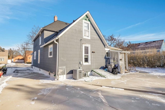 snow covered back of property with cooling unit