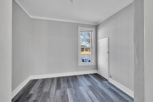 spare room with ornamental molding and dark hardwood / wood-style flooring