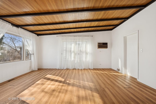 unfurnished room featuring beam ceiling, a wall unit AC, wooden ceiling, and light wood-type flooring