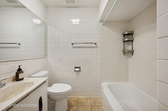 bathroom with tile walls, tile patterned flooring, vanity, a bath, and toilet