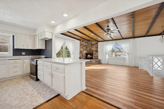 kitchen with stainless steel range with electric cooktop, light hardwood / wood-style floors, and white cabinets