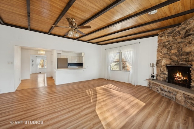 unfurnished living room with a stone fireplace, beamed ceiling, ceiling fan, light hardwood / wood-style floors, and wooden ceiling