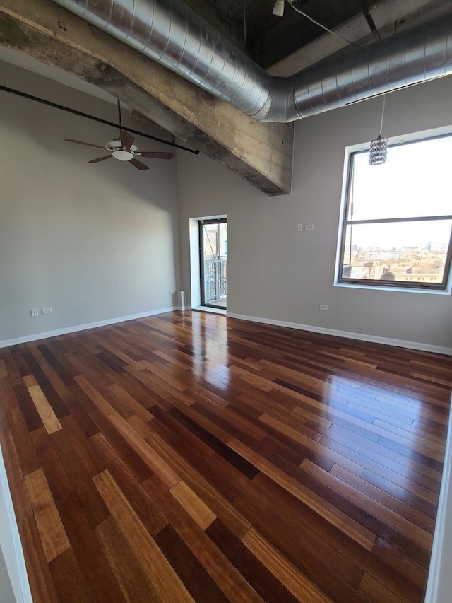 unfurnished room featuring ceiling fan, dark hardwood / wood-style floors, and vaulted ceiling