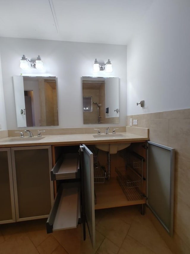 bathroom featuring tile patterned flooring, double sink, and tile walls