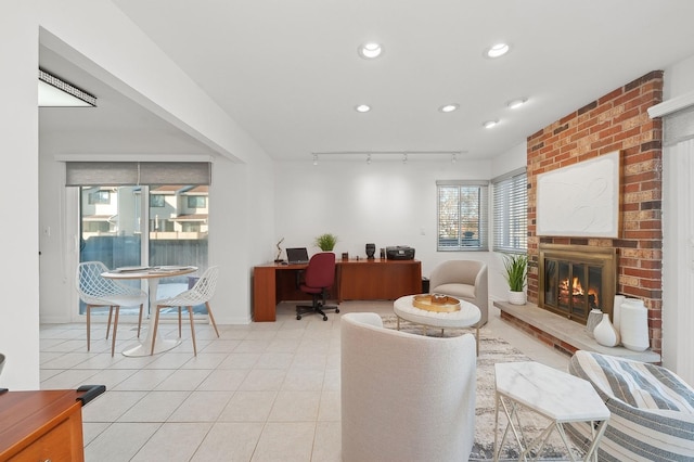 office space with light tile patterned floors, a brick fireplace, track lighting, and recessed lighting