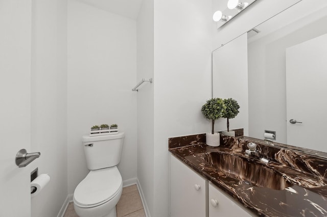 half bathroom with baseboards, vanity, toilet, and tile patterned floors