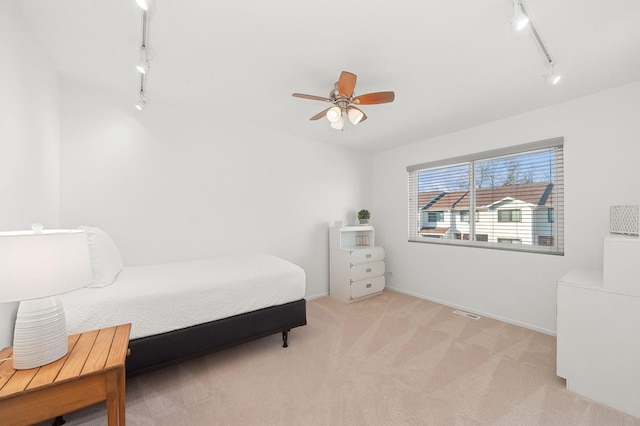 bedroom with light colored carpet, visible vents, a ceiling fan, track lighting, and baseboards