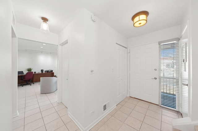 foyer entrance with light tile patterned floors, visible vents, and baseboards