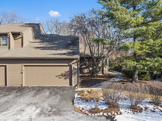 snow covered property featuring a garage