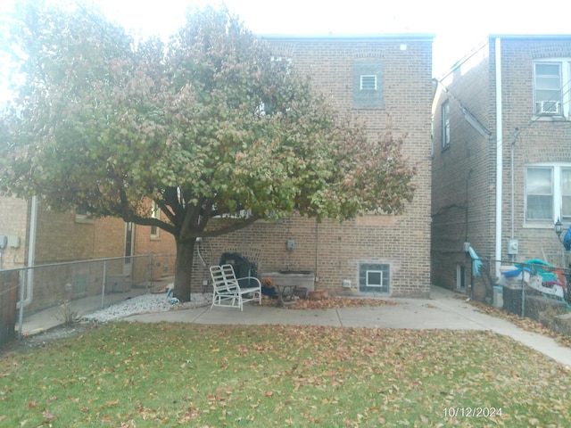 rear view of property with a patio and a lawn