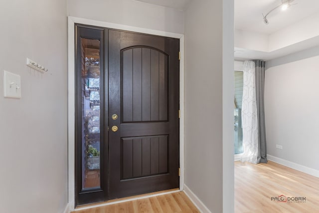 foyer entrance with track lighting and light hardwood / wood-style floors